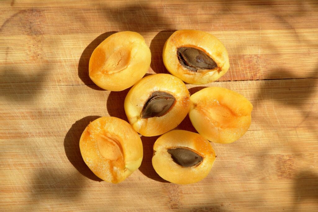 Des abricots coupés en deux, les noyaux retirés, dans un plat