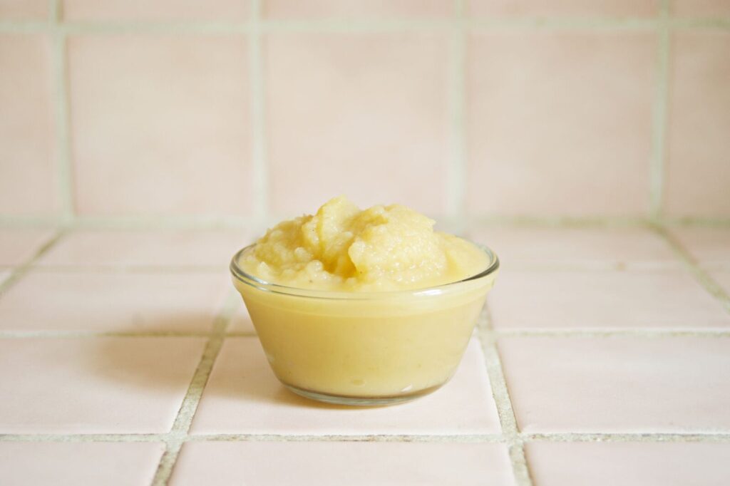 Un bol de compote de pommes encore tiède posé sur une table