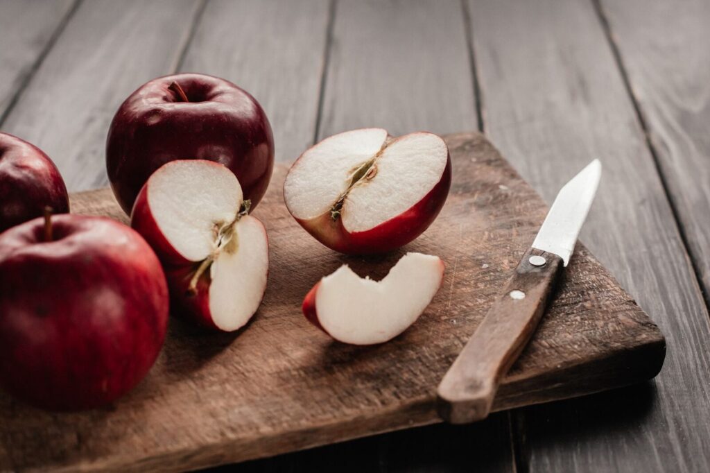 Des quartiers de pommes épluchés sur une planche en bois