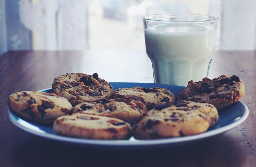 Trois cookies posés près d'un verre de lait sur une table